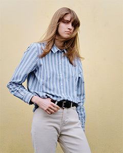 Femme portant une chemise rayée bleue avec pantalon écru | Atelier Tuffery